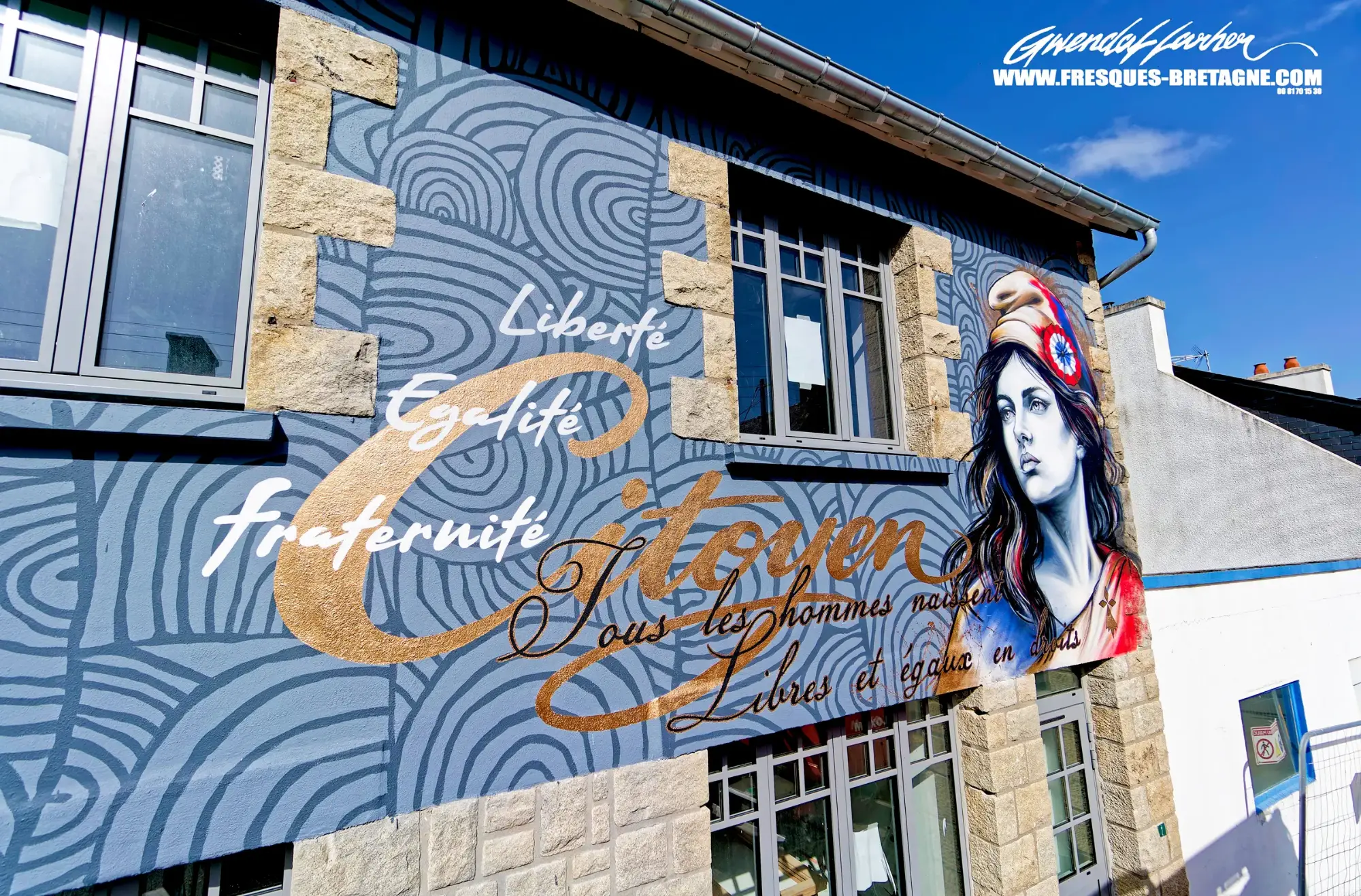 Fresque de Marianne sur la façade de la mairie de Trémel : motifs d'art pariétal des cairns en bleu-gris, mots « Liberté, Égalité, fraternité » et « Citoyen » en lettres cuivrées